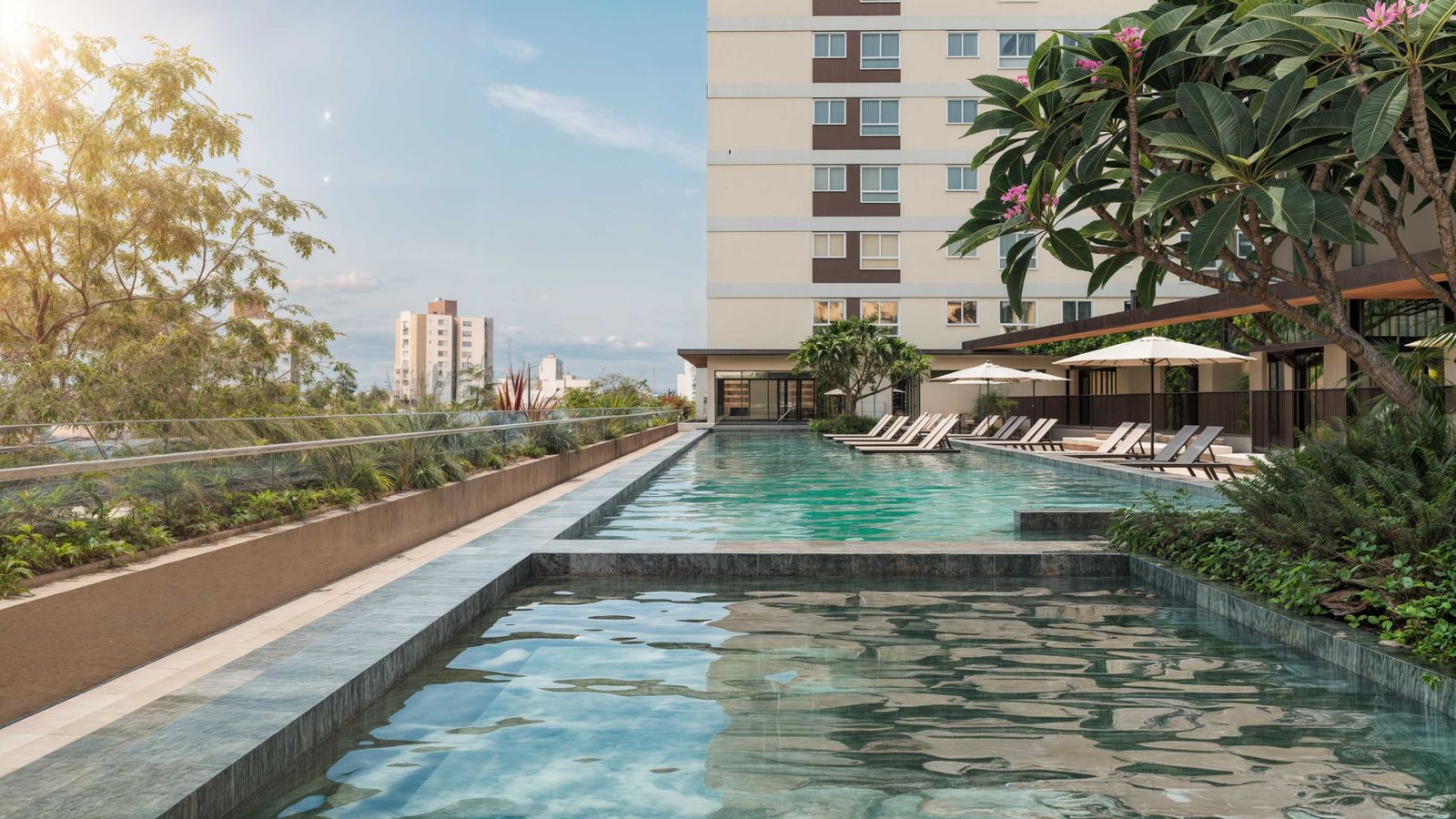 Piscina com raia semiolímpica do Portovelas, com espreguiçadeiras e paisagismo